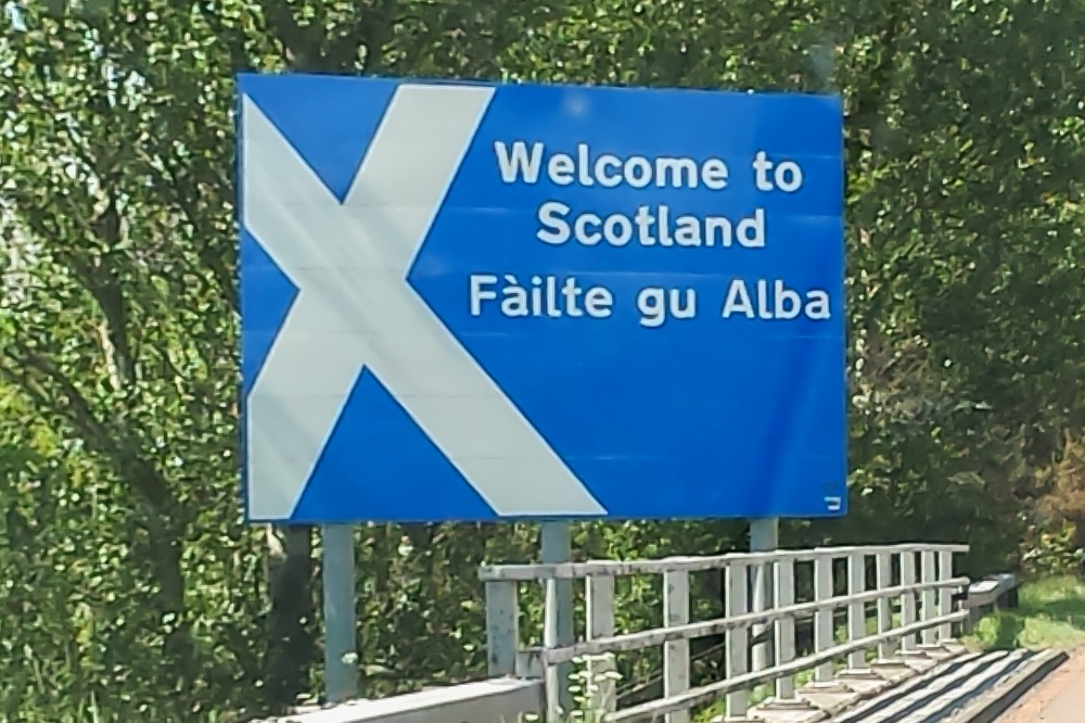 Autor: DeFacto (CC BY-SA 4.0), El cartel fronterizo bilingüe en la autopista M6 que cruza Inglaterra hacia Escocia